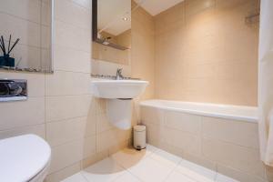 a bathroom with a sink and a toilet and a tub at Two Bedroom Flat by Brookland Stays Serviced Accommodation Short Lets London with Free WiFi in North Woolwich