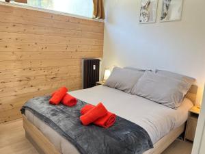 a bedroom with a bed with red pillows on it at A l'orée des bois in Égat