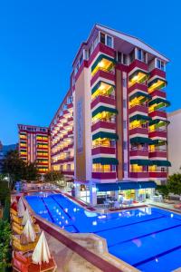 um hotel com piscina em frente a um edifício em Galaxy Beach Hotel Alanya em Mahmutlar