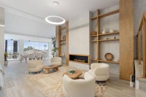 a living room with white chairs and a fireplace at Home4u Mediterranean Sea Views Villa Alkaff in Manilva