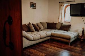 a living room with a couch and a television at Tulipános Vendégház in Szőlősardó