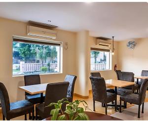 a dining room with tables and chairs and windows at Prime Park Top Rated Property in Haridwar in Haridwār