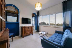 a living room with a blue couch and a tv at Terrazza Ammirati in Ischia