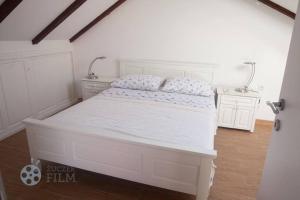 a white bedroom with a white bed with white sheets at Villa Agava in Vrboska