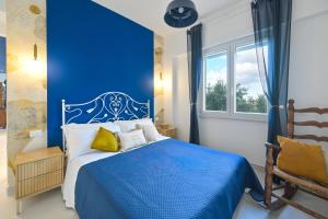 a blue bedroom with a bed and a window at Terrazza Ammirati in Ischia