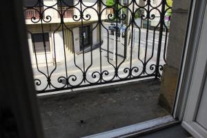 an iron gate with a view of a street at Cozy Air-Conditioned - Central - Close to Train Station in Brive-la-Gaillarde
