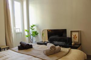 a bedroom with a bed with towels on it at Cozy Air-Conditioned - Central - Close to Train Station in Brive-la-Gaillarde