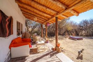 an outdoor living room with a wooden pergola at Mestiza Posada in Humahuaca