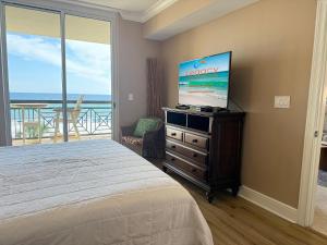 una camera da letto con un letto e una TV a schermo piatto di Azure #404 Luxurious 4BD Beachfront Condo a Fort Walton Beach
