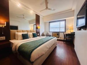 a hotel room with a large bed and a desk at Hotel Park Prime With Primmum Rooms in Haridwār