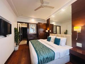 a bedroom with a large bed and a flat screen tv at Hotel Park Prime With Primmum Rooms in Haridwār