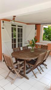 a wooden table and chairs in a room at Relaxing setting in harmony with nature in Le Moule