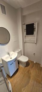 a bathroom with a toilet and a sink and a mirror at Apartament przy Starym Rynku in Poznań
