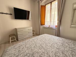 a bedroom with a bed and a tv on the wall at Duomo Appartamento in Massa Marittima