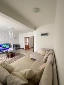 a living room with a couch and a tv at Mindelo Urban Apartment in Mindelo