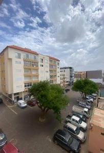 a parking lot with cars parked in front of buildings at Mindelo Urban Apartment in Mindelo