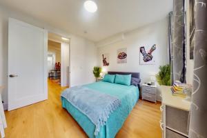 a bedroom with a bed with a blue blanket at 15 Minutes to NYC - A Fun & Colorful Getaway in Hoboken +61 photos
