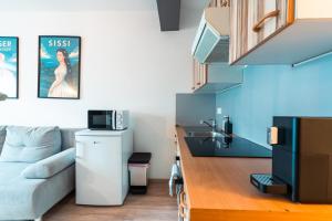 a small living room with a couch and a kitchen at Im Herzen von Bad Ischl#3 in Bad Ischl +14 photos