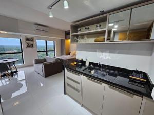 a kitchen with a sink and a living room at Tropical Executive Flat in Manaus +5 photos