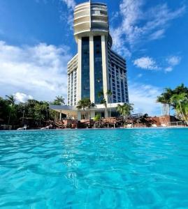 a building with a pool of water in front of it at Tropical Executive Flat in Manaus