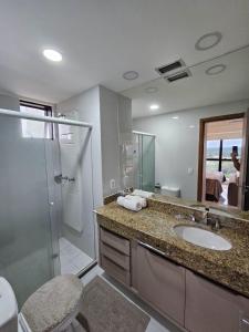 a bathroom with a sink and a shower and a toilet at Tropical Executive Flat in Manaus