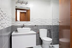 uma casa de banho com um WC, um lavatório e um espelho. em Suncity Flat Salitre II em Málaga