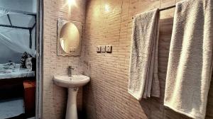 een badkamer met een wastafel en een spiegel bij Malkia Apartment in Kibigija