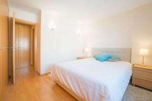 Un dormitorio con una cama blanca y suelo de madera. en 1-minute walk to the Metro and 2 to the Supermarket, en Lisboa