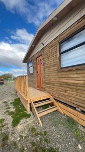 a wooden cabin with a porch and a door at Che Manuel in Puerto Natales
