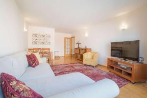 a living room with two white couches and a flat screen tv at 1 Minute to the Metro and 2 to the Supermarket in Lisbon