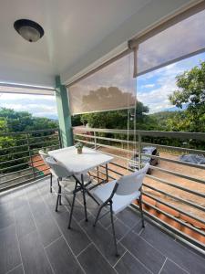 a table and chairs on a balcony with a view at apartamento cerca de aguas termales in Gracias