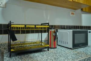 a kitchen counter with a microwave and a television at Royal Suites in Mombasa +3 photos