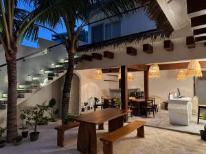 a patio with a table and chairs and palm trees at Oya Maldives Himmafushi in Himmafushi +9 photos