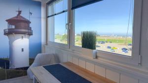 Zimmer mit Fenster und Leuchtturm in der Unterkunft Seedeich Meehrblick Alte Liebe in Cuxhaven