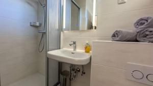 ein weißes Badezimmer mit Waschbecken und Dusche in der Unterkunft Seedeich Meehrblick Alte Liebe in Cuxhaven + 13 Fotos