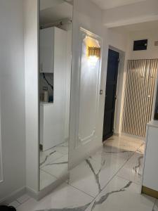 a white room with a mirror and a hallway at Apartamentul de lux in Satu Mare