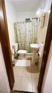 a bathroom with a toilet sink and a shower curtain at Great central room Iguazu 1B in Puerto Iguazú