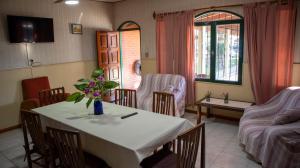 a living room with a table with chairs and a couch at Bungalows Punta Azul in Villa Carlos Paz