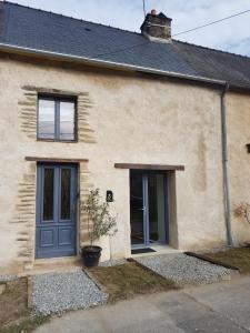 a house with a blue door and a potted plant at Dacoté Studio in La Croix-Helléan
