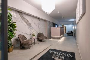 a lobby with two chairs and a table and a wall at HORIZON SUITES by the Sea in St Paul's Bay +280 photos