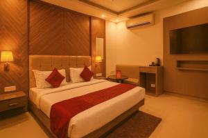 Una habitación de hotel con una cama y un televisor de pantalla plana. en Boutique Hotel Almate - Near Delhi Airport With - free Airport Pickup, en Nueva Delhi 20 fotos más
