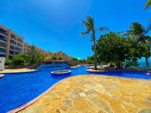 蒙巴萨Mwafrika Beachfront Apartments的一座拥有蓝色海水和棕榈树的大型游泳池