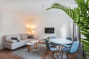 Una sala de estar con un sofá, una mesa y sillas. en Kathihomes Zentral, en Villingen-Schwenningen