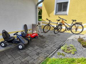 un groupe de vélos et de scooters garés à côté d'un bâtiment dans l'établissement Ferienhaus Fuchs, à Neukirchen vorm Wald
