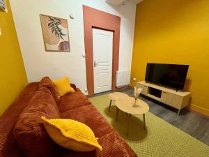 a living room with a brown couch and a flat screen tv at Grand Place Arras RDC 4 pers vidéoprojecteur in Arras