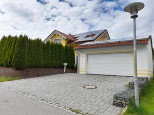 une maison avec un garage et un lampadaire dans l'établissement Ferienhaus Fuchs, à Neukirchen vorm Wald 28 autres photos