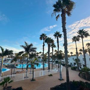 a view of a resort with palm trees and a pool at Brisa Azul in Corralejo