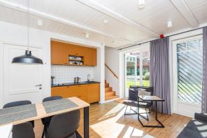 a kitchen and dining room with a table and chairs at Saulės apartamentai su vaizdu į Kušių marias in Neringa