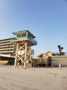 Una torre de salvavidas en una playa con un barco. en Beachside 2BR Daytona Beach Shores private home, en Daytona Beach