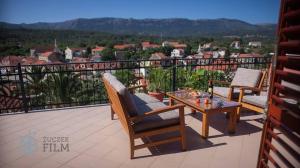 a patio with two chairs and a table on a balcony at Villa Agava in Vrboska